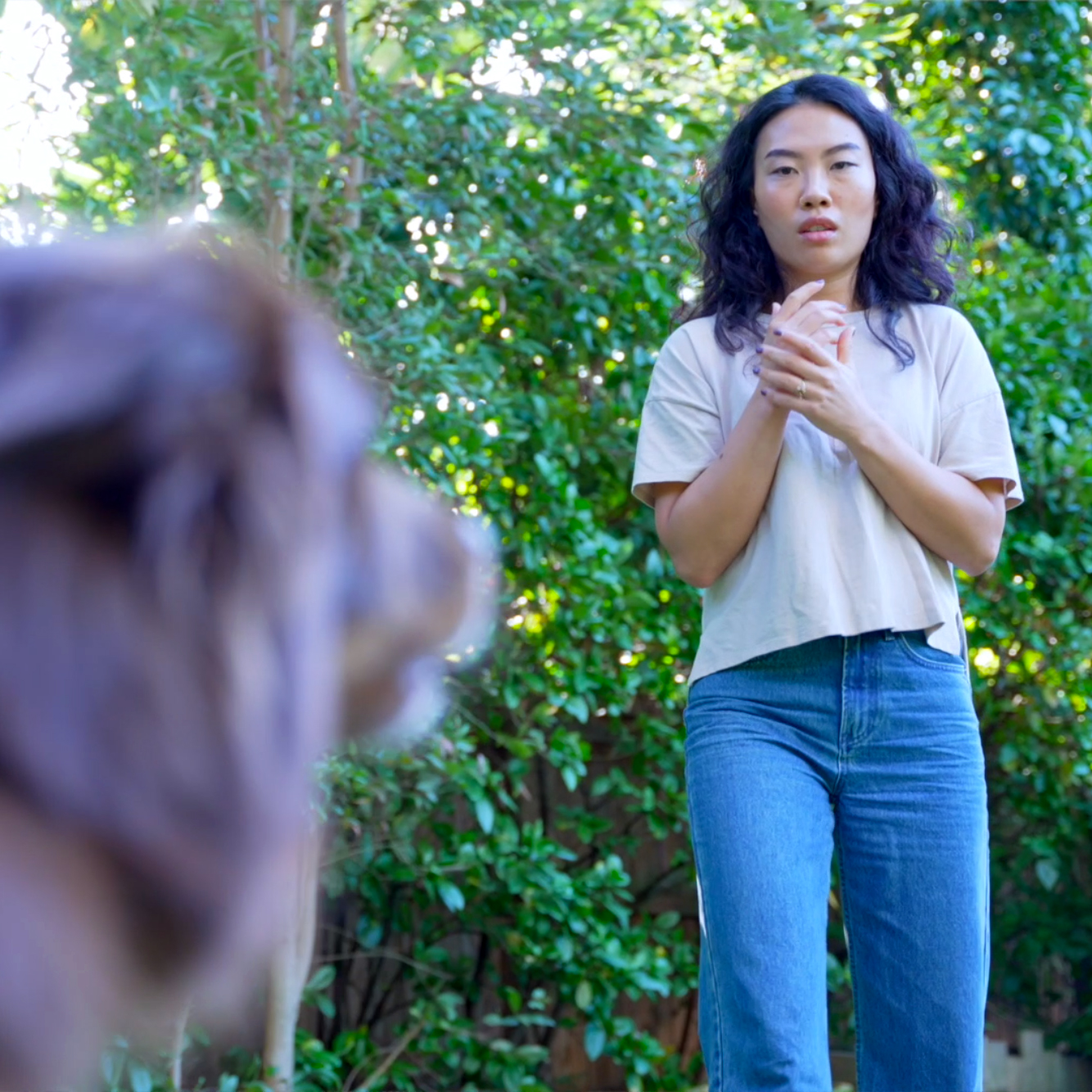 Woman appearing fearful as a dog approaches, illustrating the anxiety and distress associated with cynophobia